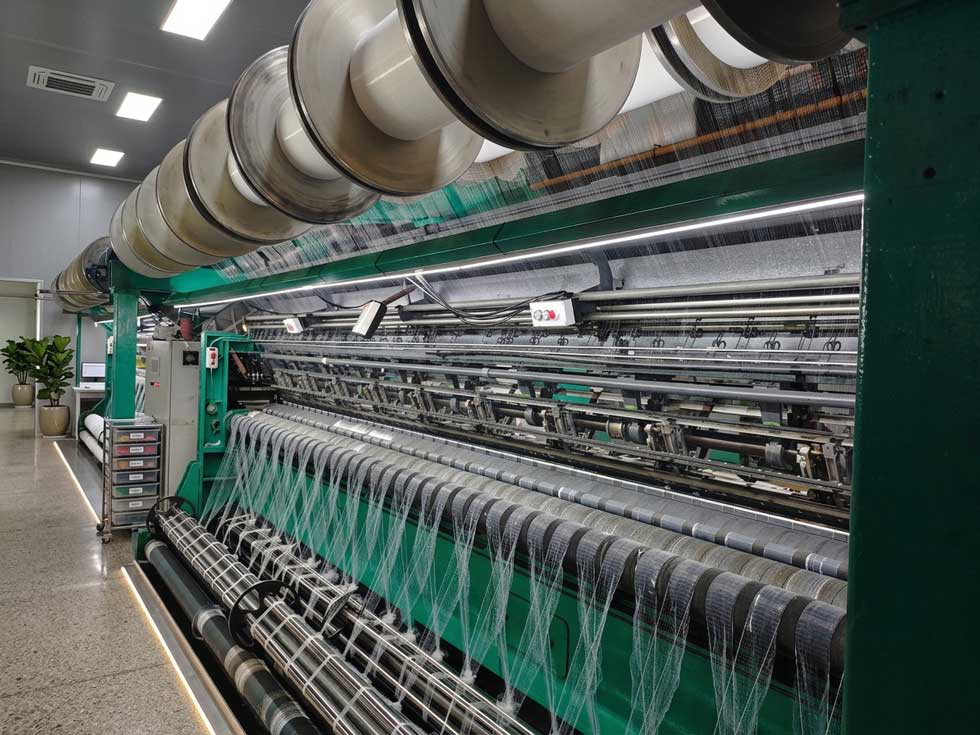 Close-up of knitting mechanism producing 15D nylon hairnet mesh